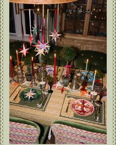 the table is set for christmas dinner with candles