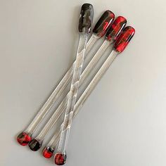 four red and silver golf clubs on a white surface