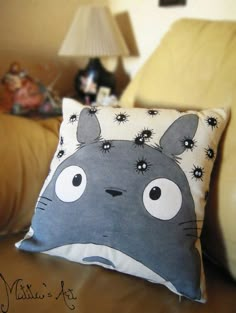 a pillow with an image of totoro sitting on it's back cushion