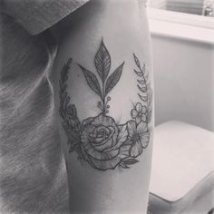 a black and white photo of a woman's arm with a rose tattoo on it