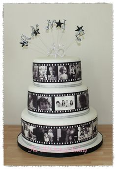 a three tiered cake decorated with black and white film strips, stars and the word love