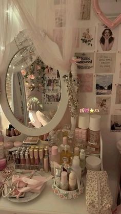 a vanity with lots of items on it and a round mirror above the counter top