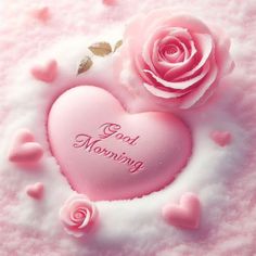 two pink roses sitting on top of a heart shaped cake with the words good morning