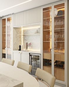 a white dining room table and chairs with wine glasses