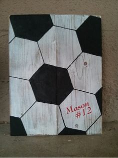 a wooden sign with a soccer ball painted on it