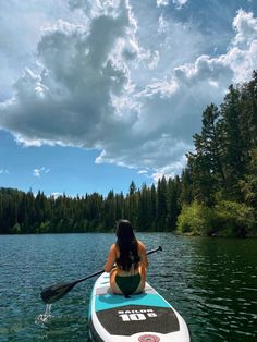 a woman sitting on top of a paddle boat in the water