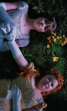 two young women laying on the ground next to each other wearing white gloves and dresses