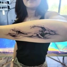 a woman with a wave tattoo on her arm