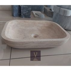 a stone sink sitting on top of a tiled floor