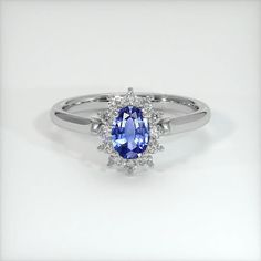 a blue and white diamond ring on a white surface with the center stone surrounded by smaller diamonds