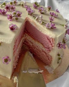 a cake with white frosting and pink flowers on it