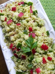 a white plate topped with cucumber and radishes on top of a table