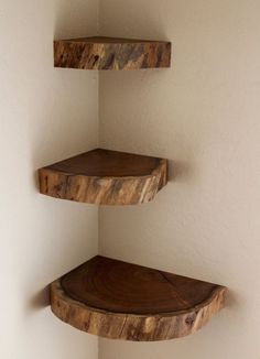 three wooden shelves in the corner of a room