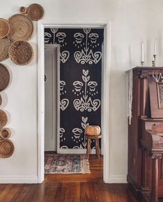 a room with a piano and several baskets on the wall