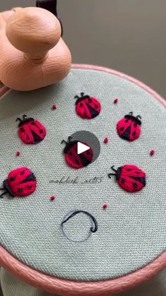 someone is stitching ladybugs on the fabric