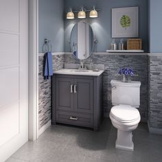 a white toilet sitting next to a sink in a bathroom under a mirror and lights