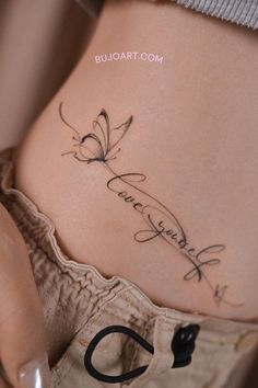 a woman's stomach with a butterfly tattoo on her belly and the word love written in cursive writing