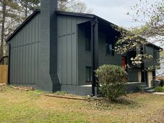 a black house sitting on top of a lush green field