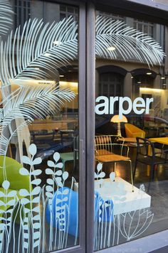 an open window with chairs and tables in front of the glass that says arper