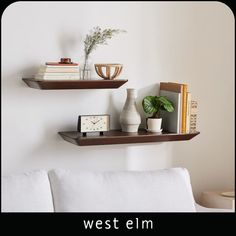 two shelves with books, vases and other items on them in a living room