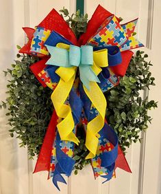 a wreath with puzzle pieces on it hanging from the front door for someone's house