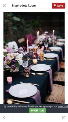 the table is set with white plates and purple napkins, candles and flowers in vases