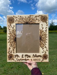 a person holding up a wooden frame with the words mr and mrs adams on it