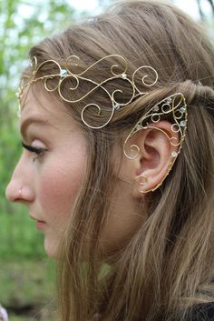 a woman with long hair wearing a gold head piece