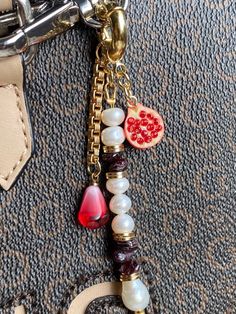 This piece of jewelry can be used as a bag charm, a keychain, or a decoration for any other item.  * Gold: Brass/copper/St.steel + 18K Gold plated * Platinum: Brass/copper/St.steel + Rhodium plated * Freshwater &  Baroque pearls; Natural Garnet stones; Zircon pendant * No risk of allergy (nickel-free, lead-free, cadmium-free) * Full length: 90 mm * The shape and color of the stones and pearls may vary * Delivered with a cleaning cloth and a ready-to-gift jewelry storage pouch * FREE USAVEL GIFT Cheap Keychain Bag Charm As Gift, Luxury Logo Bag Charm For Gift, Luxury Logo Bag Charm As Gift, Rectangular Keys Bag Charm For Gift, Elegant Bag Charm With Charms As Gift, Bags Business, Purse Keychain, Accessories Bag, Pearl Bag