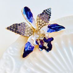 This Gorgeous Purple Orchid Brooch is perfect for adding a touch of elegance to any outfit. With its stunning purple color and sparkling rhinestone accents, it is sure to catch the eye and make a statement. Wear it on a coat, dress, or shirt to add a touch of sophistication to your look. This brooch makes a wonderful present for someone special to you. Dimensions: 5cm*4.7cm Materials: Alloy, rhinestone The Purple, Purple Orchids, Halloween Jewelry, Purple Color, Orchids, Violet, Sparkle, Halloween, Purple