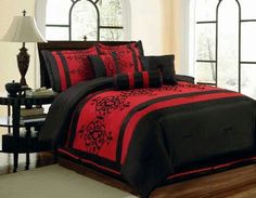 a bed with red and black comforters in a room