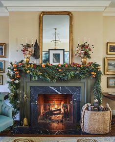 a fireplace decorated for christmas with greenery and oranges