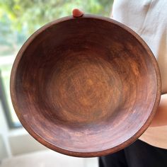 a person holding a wooden bowl in their hand