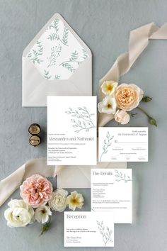 the wedding stationery is laid out with flowers