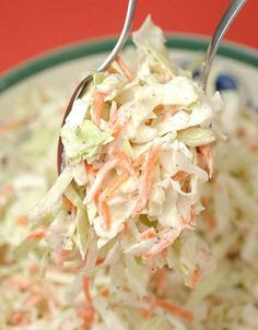 a spoon full of coleslaw with carrots and lettuce on it