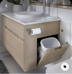 a bathroom with a sink, mirror and toilet paper dispenser in it