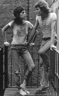 two young men standing on a balcony with their arms around each other