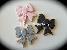 three decorated cookies with bows on them