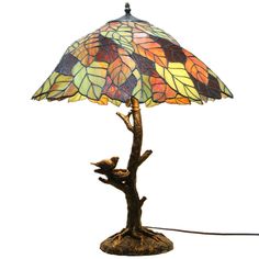 a lamp that is sitting on top of a tree branch and has a bird perched on it