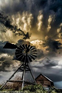 a windmill in front of a cloudy sky