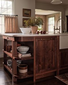 a kitchen with wooden cabinets and an island in front of the sink is filled with dishes