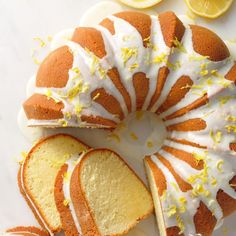 a bundt cake with lemon drizzles on it and slices cut out