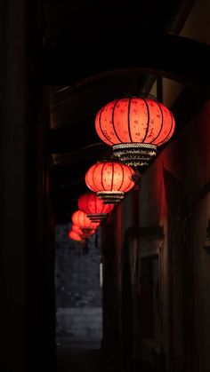 red lanterns hanging from the ceiling in an alley