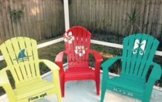 three colorful plastic chairs sitting on top of a patio