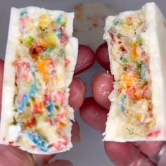 two hands holding small pieces of cake with sprinkles