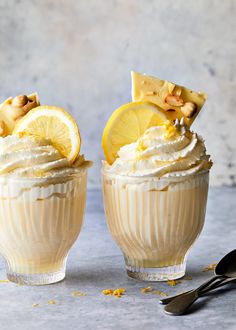 two dessert cups filled with whipped cream and lemon slices