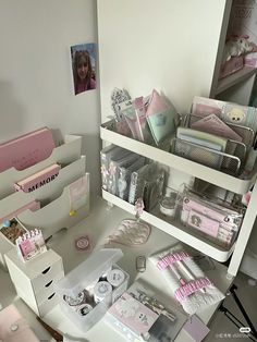 a white desk topped with lots of boxes filled with baby items next to a mirror