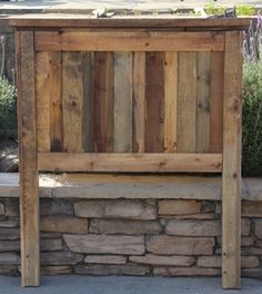 a wooden bench sitting next to a stone wall