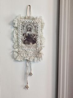 an old photo hanging on the side of a door with tassels around it