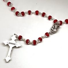 Dimensions: H 22.4" Description: Made of magnificent red coral, this rosary is skillfully hand carved by Christian craftsmen to create a beautiful and a classic piece for Christians around the world. Works as a perfect first communion gift or for personal use, this exquisite rosary will be a constant reminder of the serenity of the Holy Spirit, and the importance of praying to Virgin Mary of is always watching over us. The centerpiece for this gorgeous Bethlehem Rosary is Virgin Mary with Jesus Crucifix Jewelry With Faceted Beads For Gift, Crucifix Jewelry With Faceted Beads As Gift, Crucifix Shaped Jewelry With Faceted Beads As Gift, Red Spiritual Rosary As Gift, Gift Rosary With Polished Beads And Cross, Faceted Beads Crucifix Rosary As Gift, Gift Rosary With Polished Beads, Red Spiritual Cross Pendant Jewelry, Adjustable Red Cross Necklace